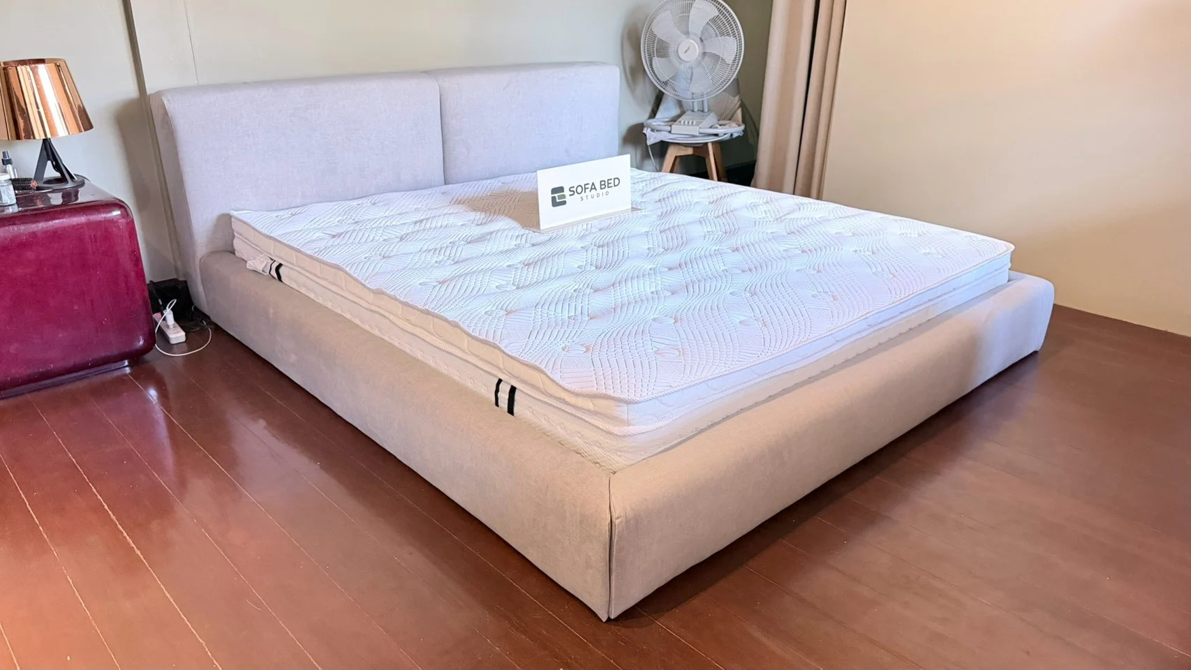 เตียงหัวพาแนลคู่สีอ่อนพร้อมฟูกในห้องพื้นไม้ · Sofa Bed Studio · DP-060