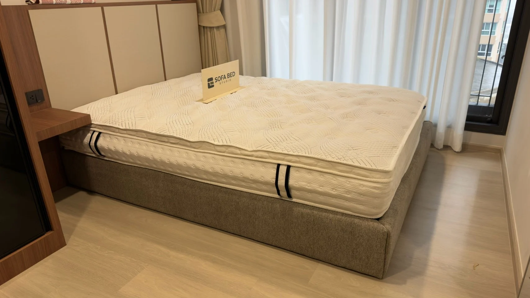 ฐานเตียงบุหุ้มสีเทาพร้อมฟูกในห้องนอน · Sofa Bed Studio · BF-023