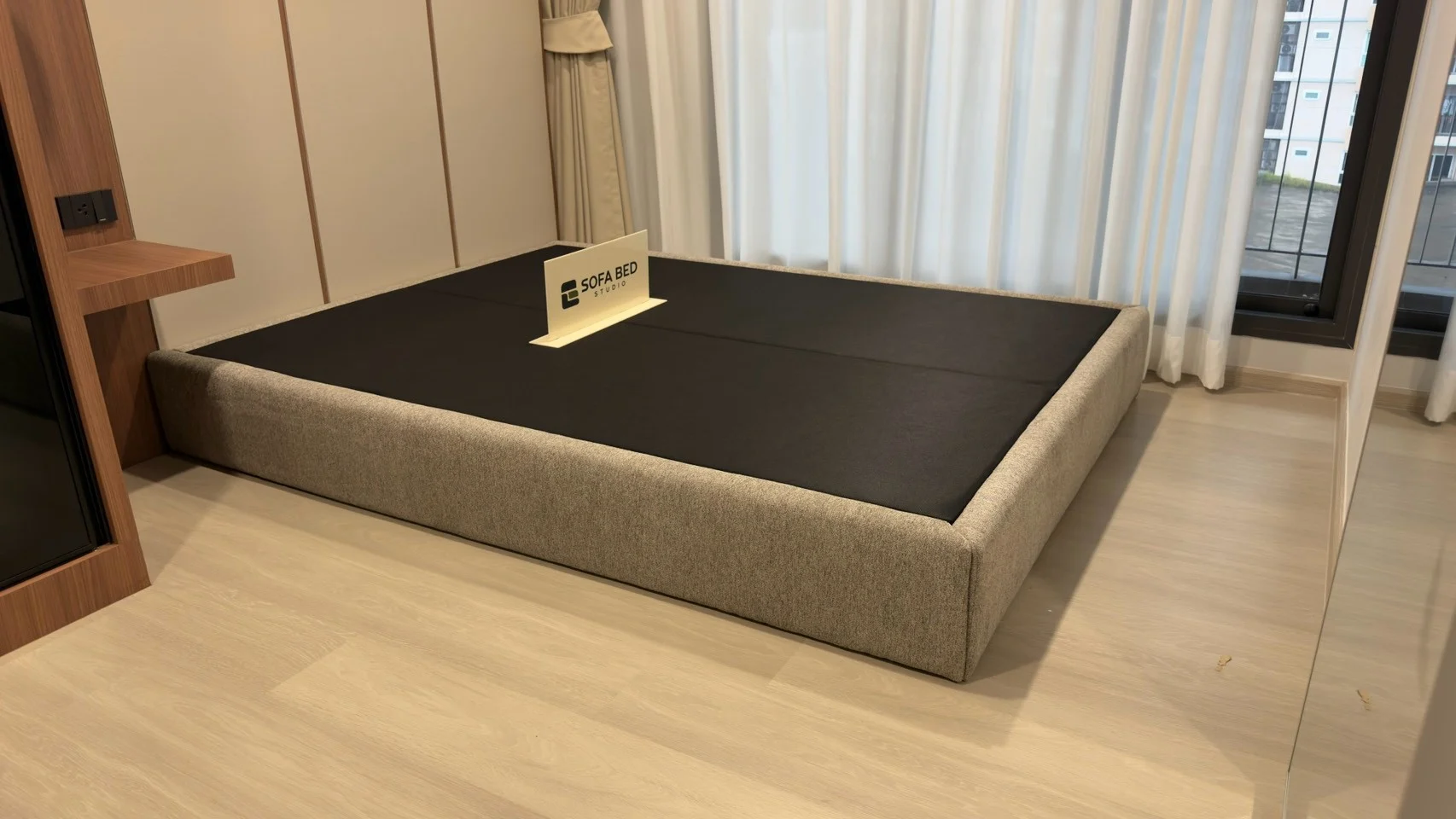 ฐานเตียงบุหุ้มสีเทาทรงเรียบมองจากปลายเตียง · Sofa Bed Studio · BF-024