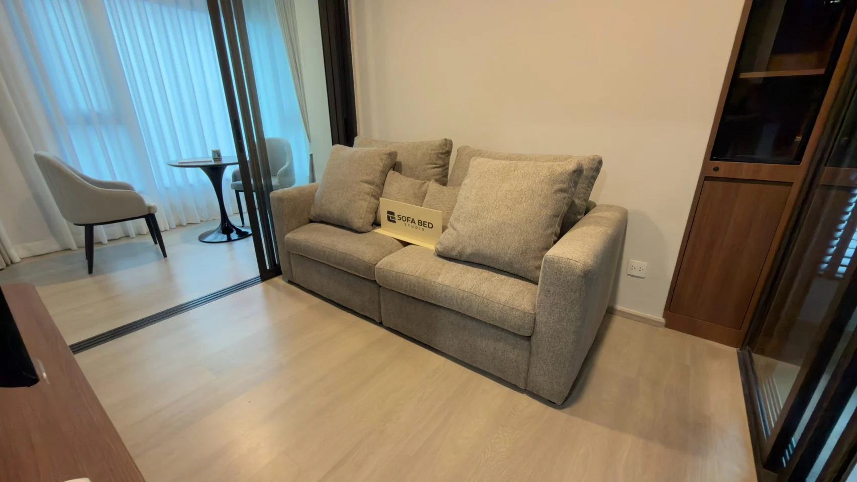 Grey two-seat sofa with cushions in a living room